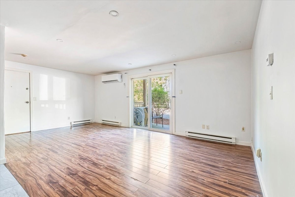 90-92 Sandwich Road, Unit 2D Bourne, MA 02532 - Photo 2 of 29 a view of an empty room with wooden floor and a window
