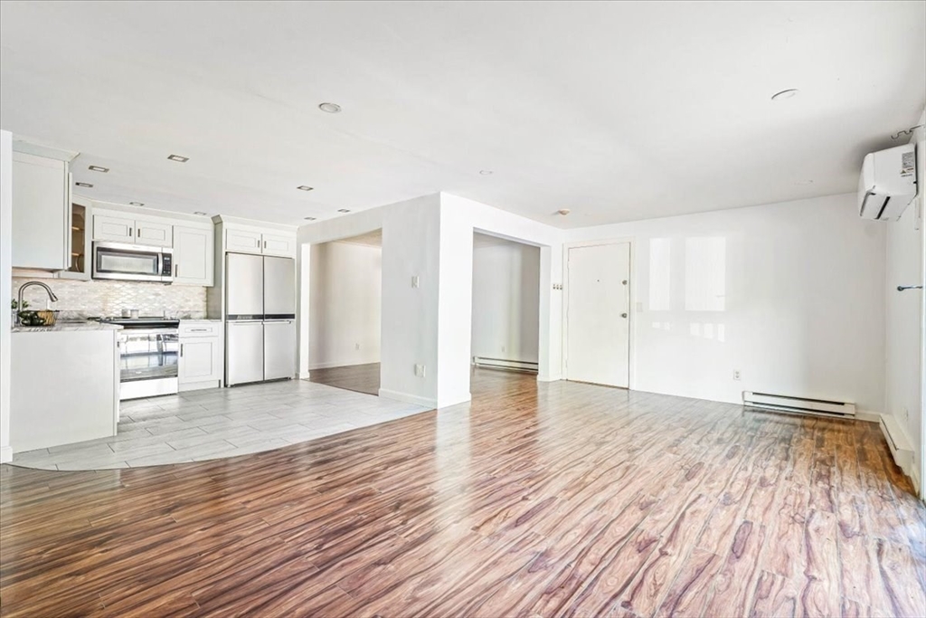 90-92 Sandwich Road, Unit 2D Bourne, MA 02532 - Photo 23 of 29 a view of a kitchen with wooden floor and a refrigerator