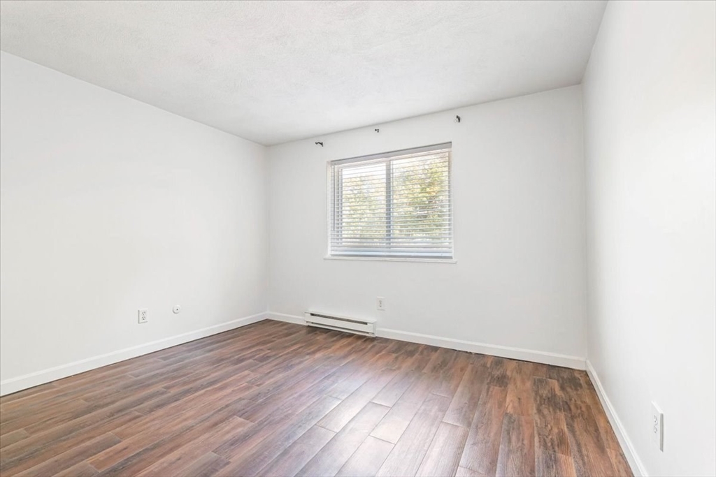 90-92 Sandwich Road, Unit 2D Bourne, MA 02532 - Photo 6 of 29 an empty room with wooden floor and windows