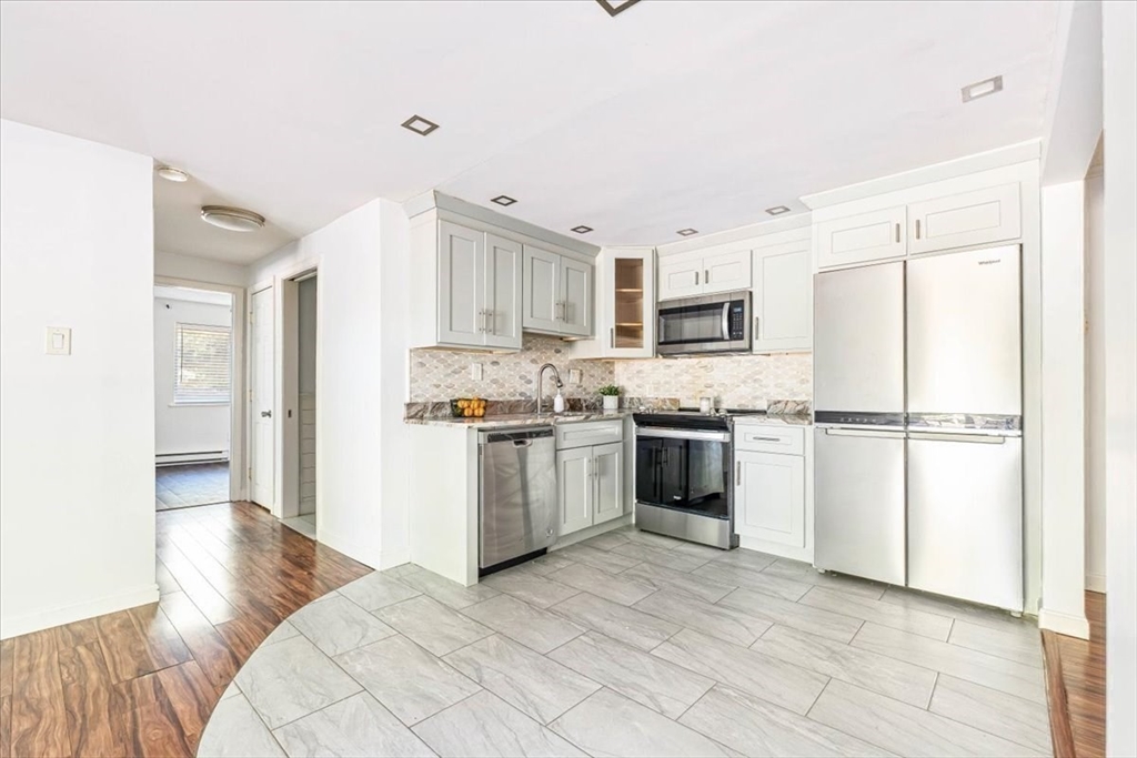 90-92 Sandwich Road, Unit 2D Bourne, MA 02532 - Photo 10 of 29 a kitchen with a refrigerator a stove top oven a sink and dishwasher