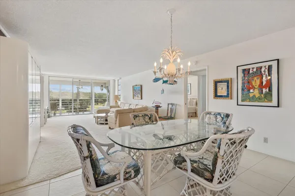 a dining room with furniture a chandelier and window