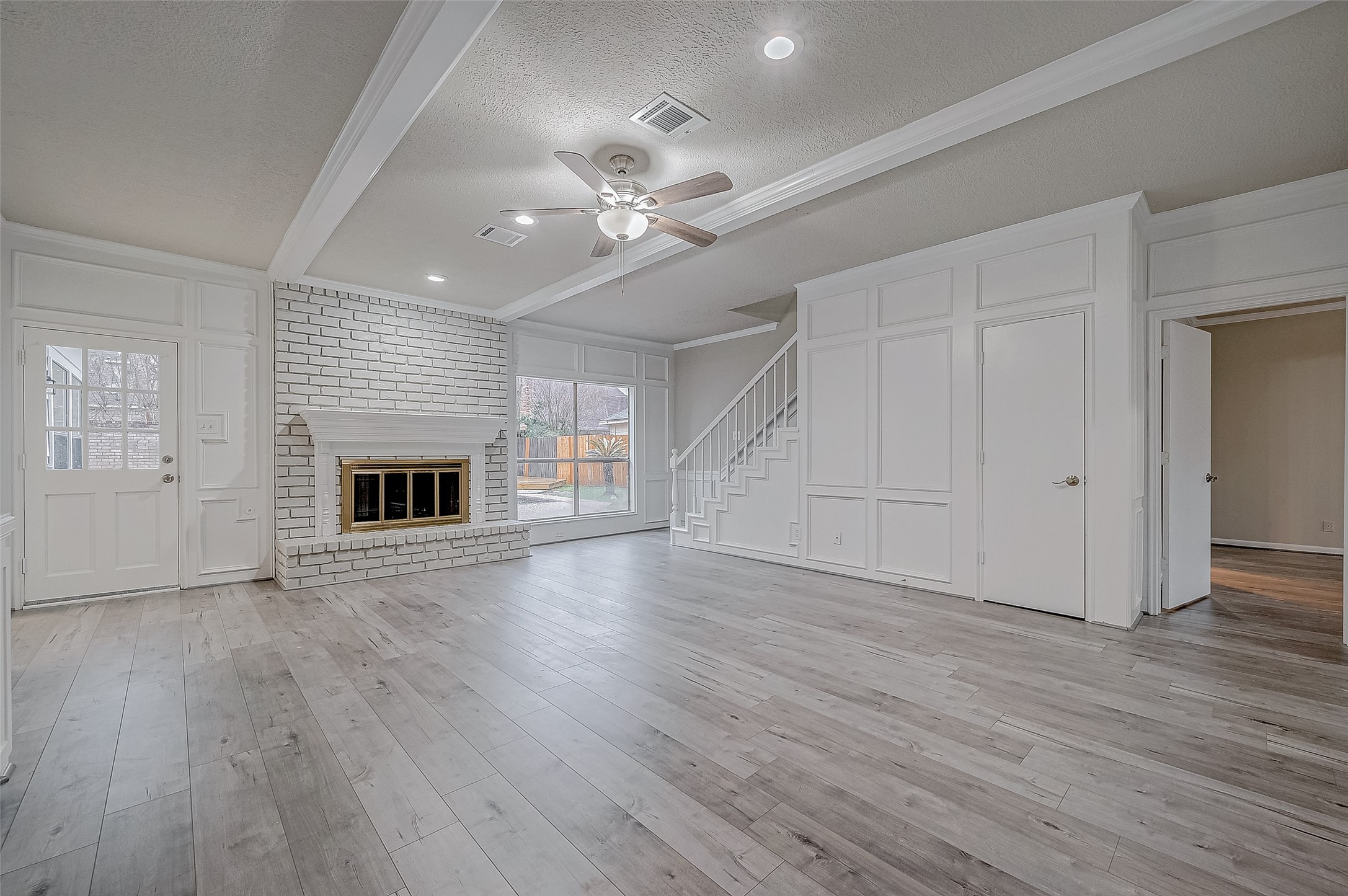 4218 Bayglen Court Houston, TX 77068 - Photo 10 of 42 an empty room with wooden floor fireplace and ceiling fan