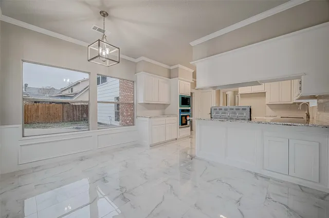 a large white kitchen with cabinets and a refrigerator