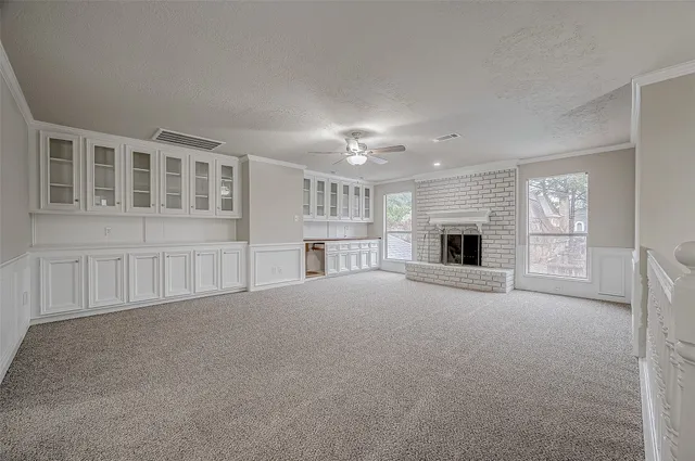 a view of an empty room with a fireplace and a window