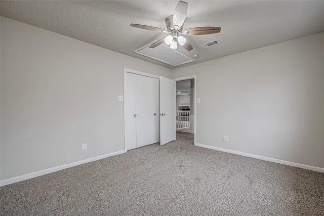 an empty room with a chandelier fan and a ceiling fan