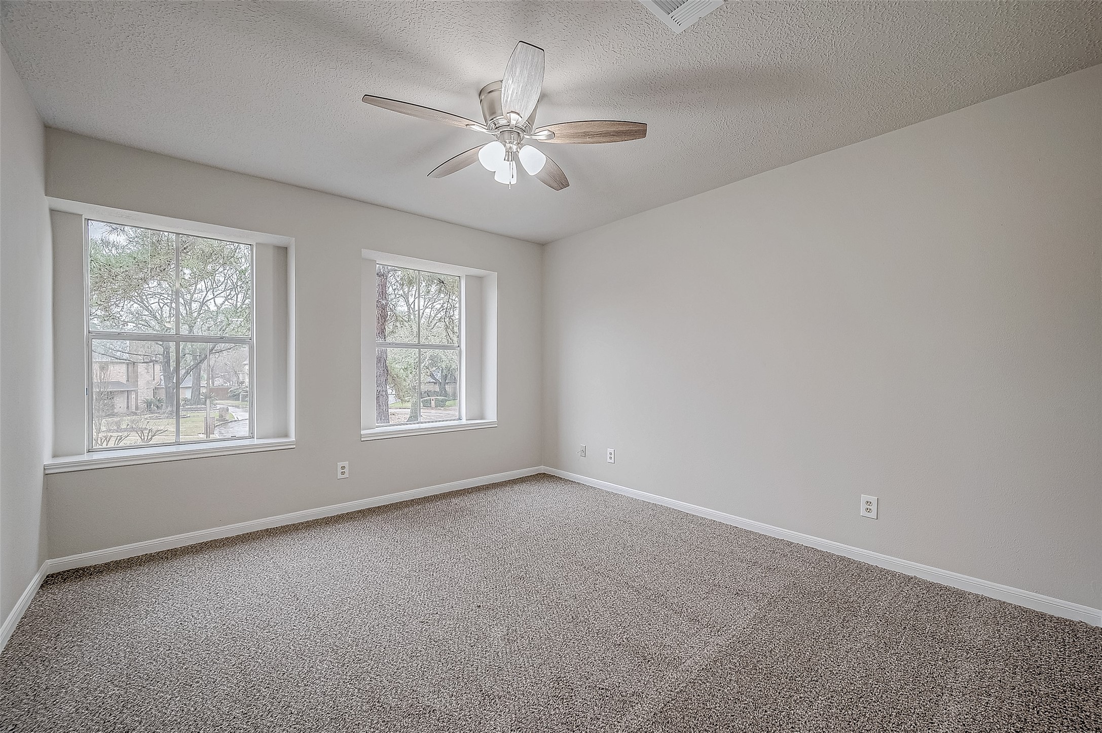 4218 Bayglen Court Houston, TX 77068 - Photo 27 of 42 an empty room with chandelier fan and windows