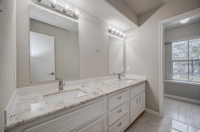 a bathroom with a granite countertop sink and a mirror