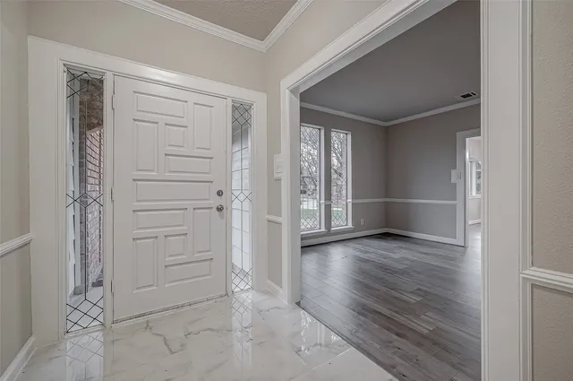 an empty room with wooden floor closet and windows