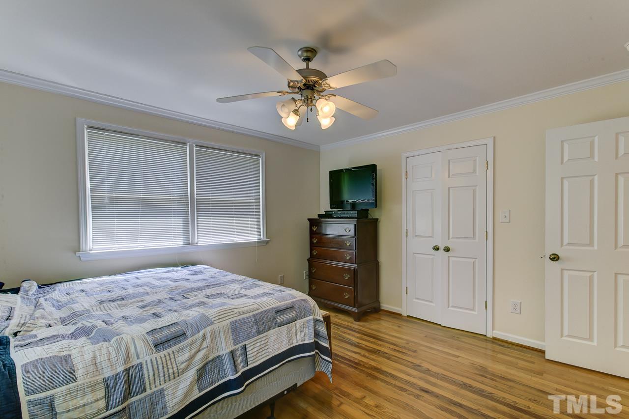 3432 Leonard Street Raleigh, NC 27607 - Photo 14 of 25 a bedroom with a bed and a chandelier
