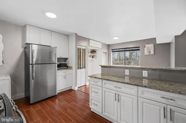 a kitchen with granite countertop a stove sink and cabinets