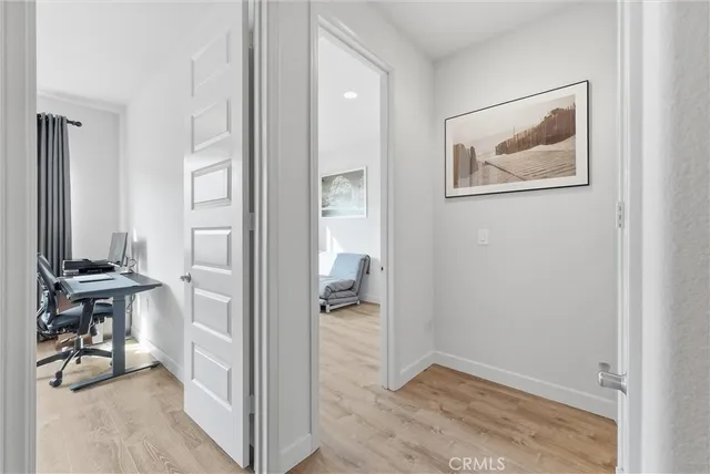 a view of a hallway with bathroom and wooden floor