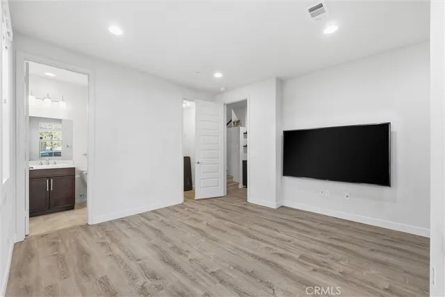 a view of a livingroom with wooden floor and a flat screen tv