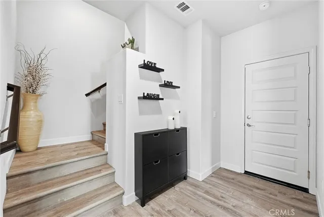 a view of a hallway with wooden floor and staircase