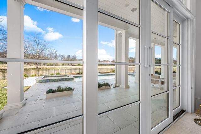 a dining room with furniture and a floor to ceiling window