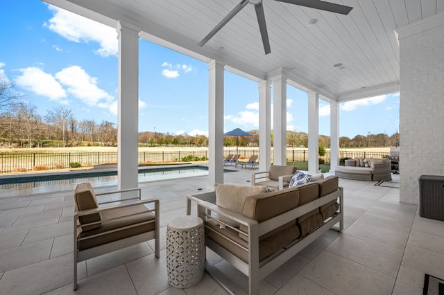 a view of a golf ground with a large trees