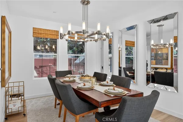 a dining room with furniture a chandelier and wooden floor