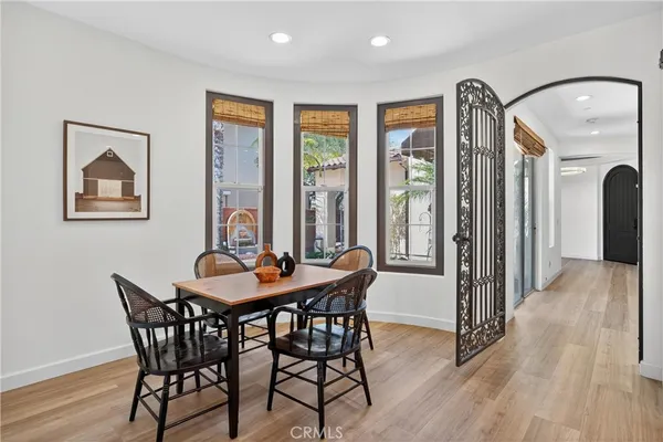a kitchen with stainless steel appliances granite countertop a dining table chairs and couches with wooden floor