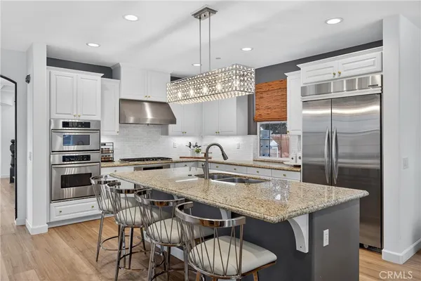 a living room with furniture large window and wooden floor