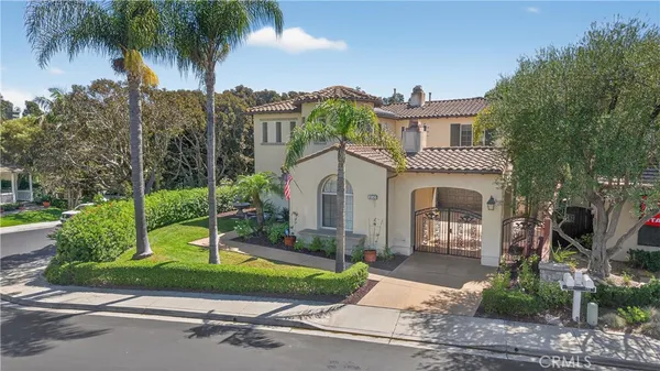 a front view of a house with a yard and palm trees