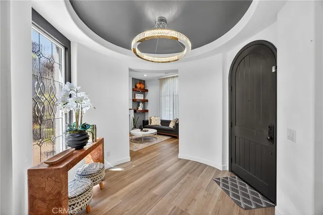 a dining room with furniture a chandelier and wooden floor