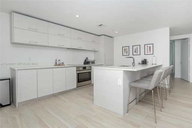 a kitchen with a sink cabinets and wooden floor