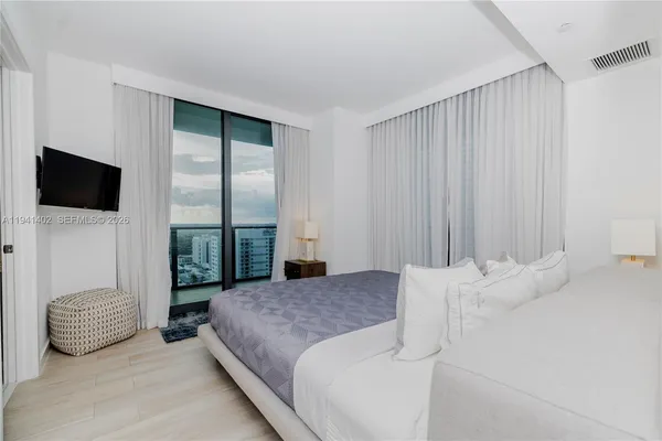 a bedroom with a bed and a flat screen tv