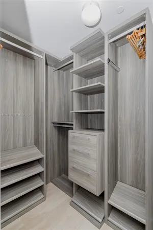a view of walk in closet with empty racks