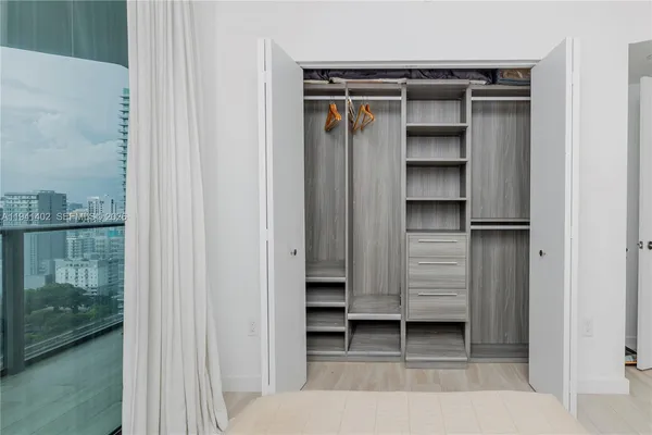 a view of walk in closet with clothes and shoes