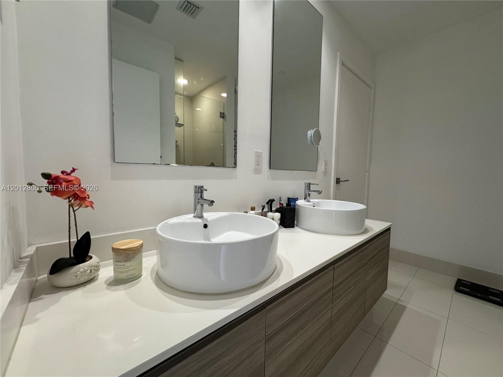 121 Northeast 34th Street, Unit L601 Miami, FL 33137 - Photo 11 of 32 a bathroom with a double vanity sink and a mirror