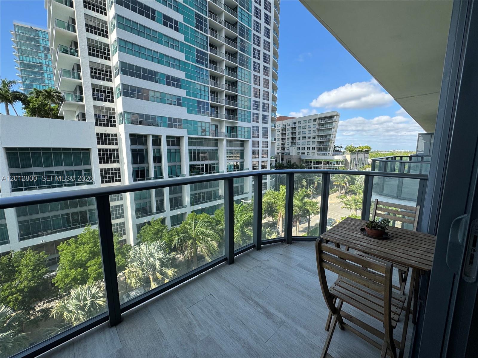 121 Northeast 34th Street, Unit L601 Miami, FL 33137 - Photo 17 of 32 a view of a balcony with chairs and wooden floor