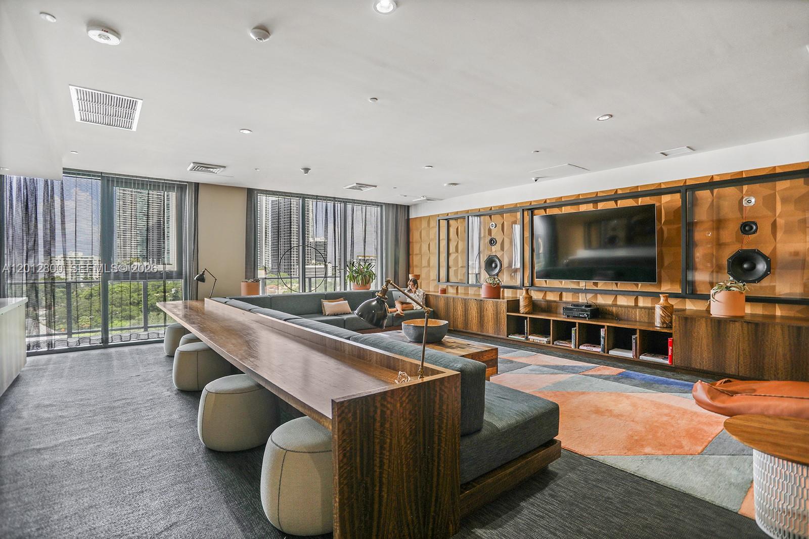 121 Northeast 34th Street, Unit L601 Miami, FL 33137 - Photo 20 of 32 a living room with furniture a flat screen tv and floor to ceiling window