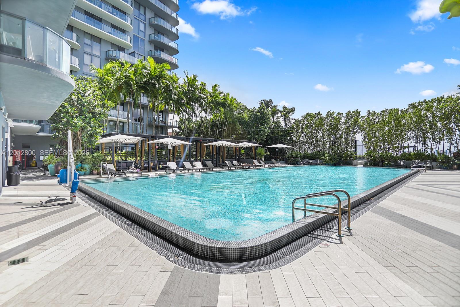 121 Northeast 34th Street, Unit L601 Miami, FL 33137 - Photo 27 of 32 a view of a swimming pool with lawn chairs and plants