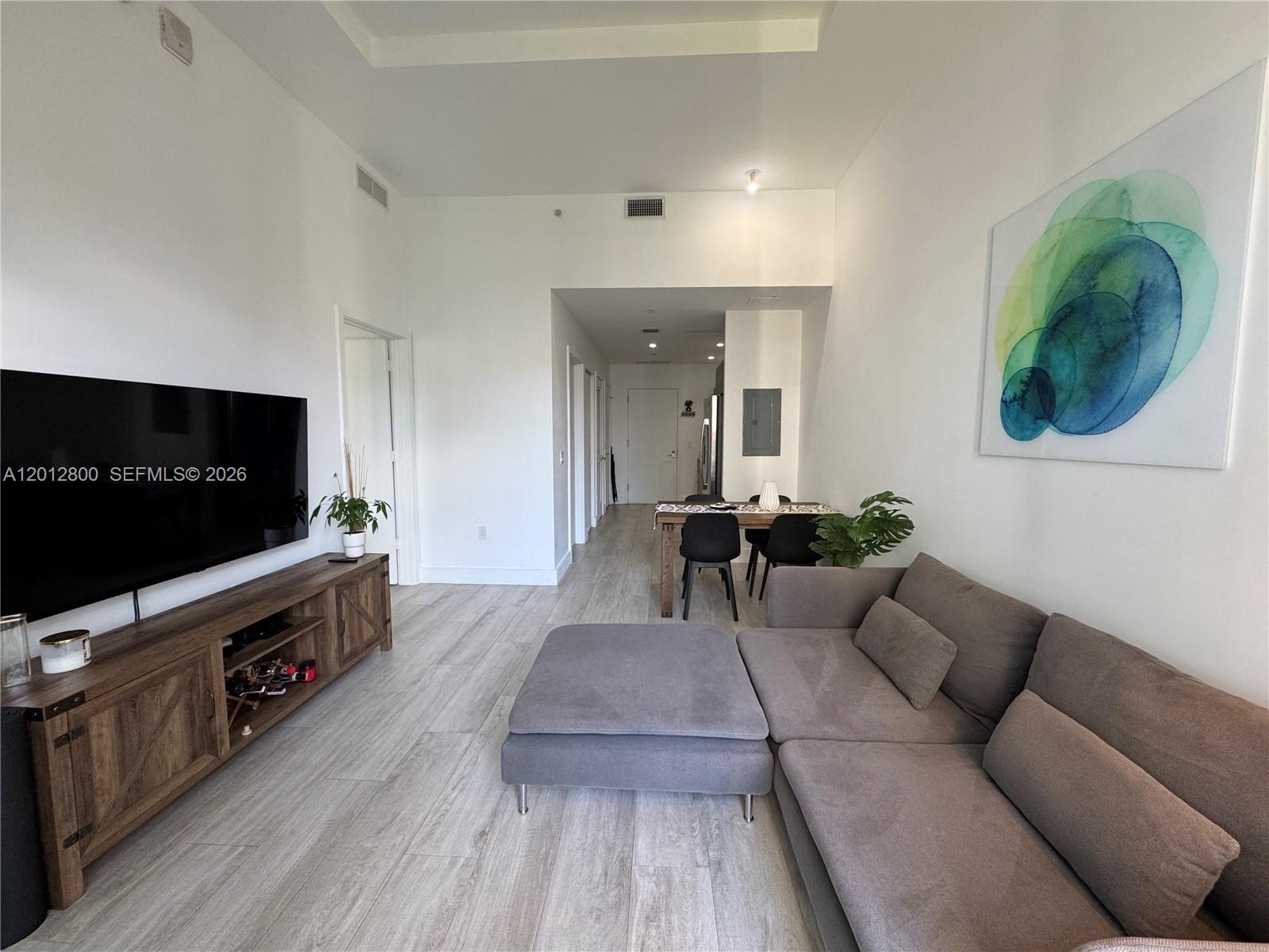 121 Northeast 34th Street, Unit L601 Miami, FL 33137 - Photo 6 of 32 a living room with furniture and a flat screen tv