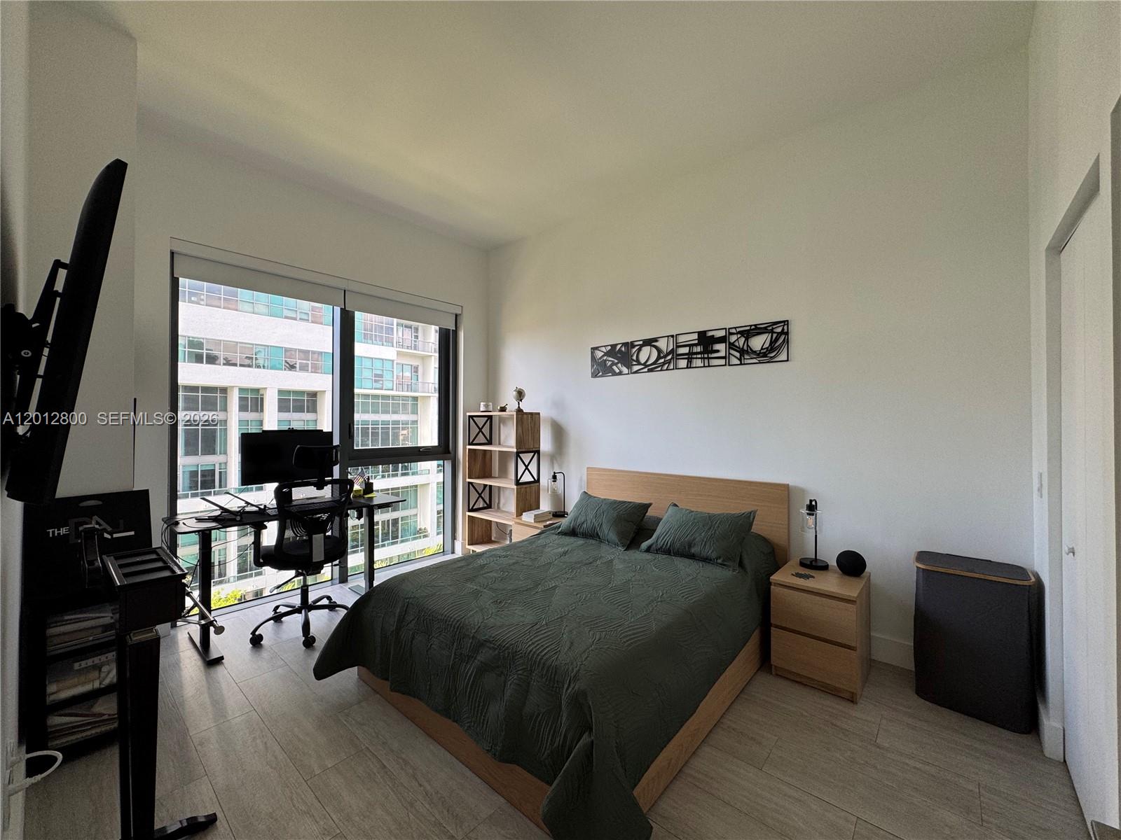 121 Northeast 34th Street, Unit L601 Miami, FL 33137 - Photo 7 of 32 a bedroom with a bed and a table