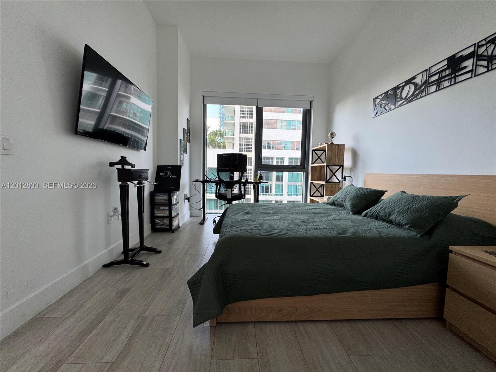121 Northeast 34th Street, Unit L601 Miami, FL 33137 - Photo 8 of 32 a bedroom with a bed couch tv and a window