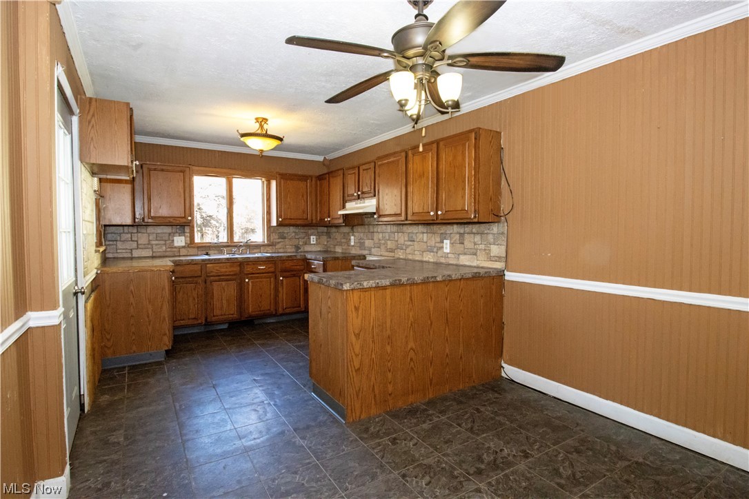 1934 Sherman Road Wooster, OH 44691 - Photo 13 of 23 Kitchen with dark tile floors, ceiling fan, kitchen peninsula, and backsplash