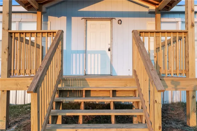 a view of a balcony with wooden floor and fence