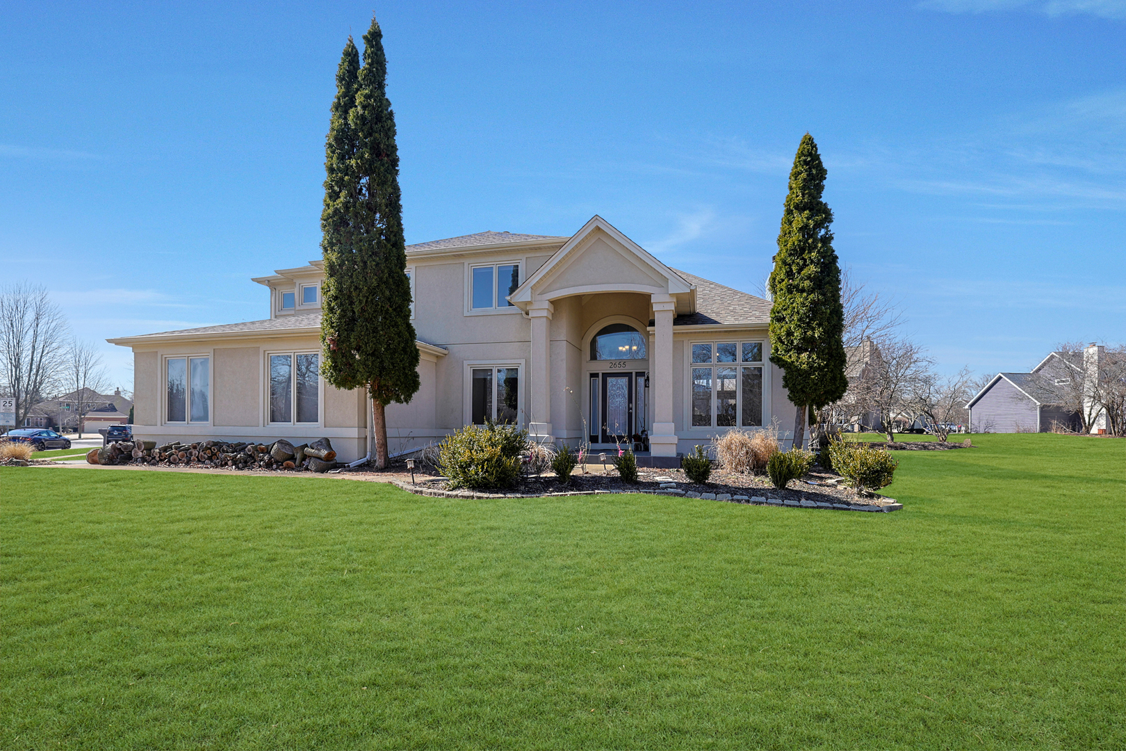 a front view of a house with a garden and trees