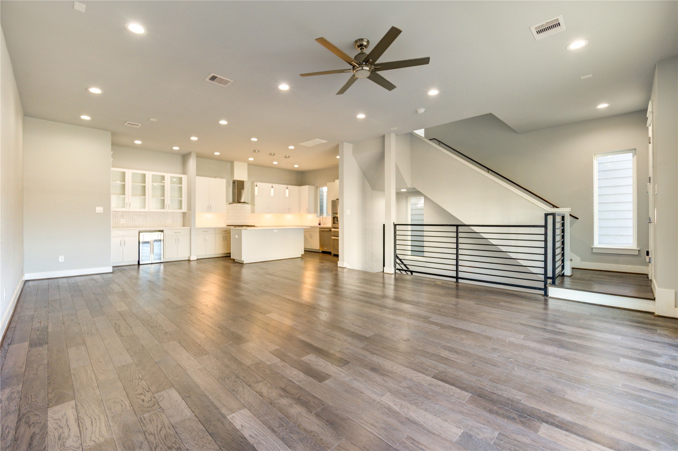 3306 Cline Street Houston, TX 77020 - Photo 6 of 30 a view of an empty room with wooden floor and a kitchen view