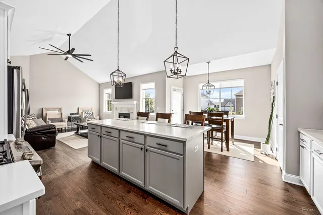 a large kitchen with a counter space a sink appliances and wooden floor