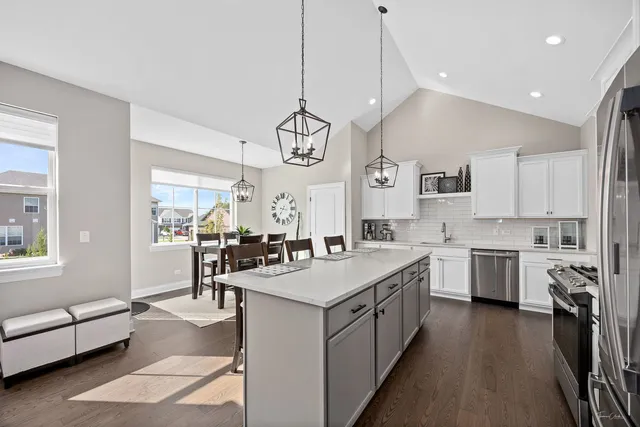 a large kitchen with kitchen island a large counter space a sink appliances and cabinets