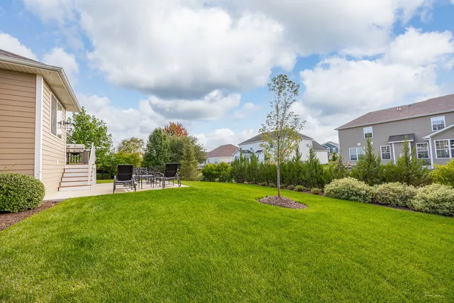 a view of a house with a big yard and potted plants