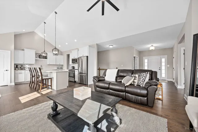 a living room with stainless steel appliances kitchen island dining table and chairs
