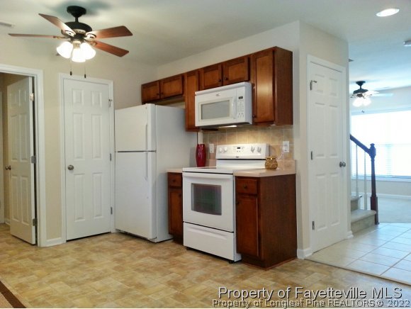 75 Holly Oak Circle Bunnlevel, NC 28323 - Photo 4 of 25 a kitchen with stainless steel appliances a stove a microwave and a refrigerator