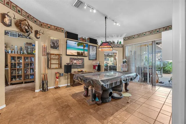 a kitchen with stainless steel appliances a stove a sink a refrigerator and chairs