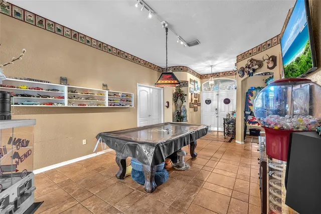 a dining hall with stainless steel appliances kitchen island granite countertop a table and chairs in it