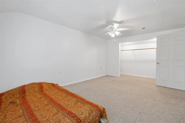 an empty room with a ceiling fan and a window