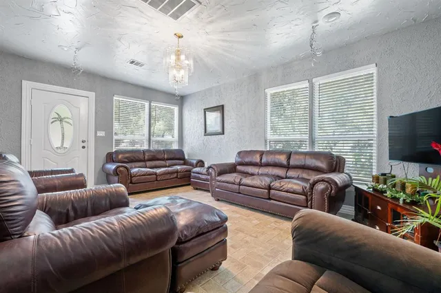 a living room with furniture a large window and a flat screen tv