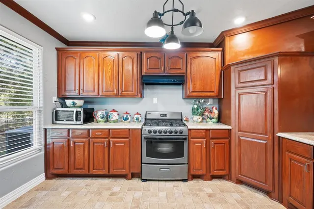 a kitchen with stainless steel appliances granite countertop a stove a sink dishwasher and a refrigerator