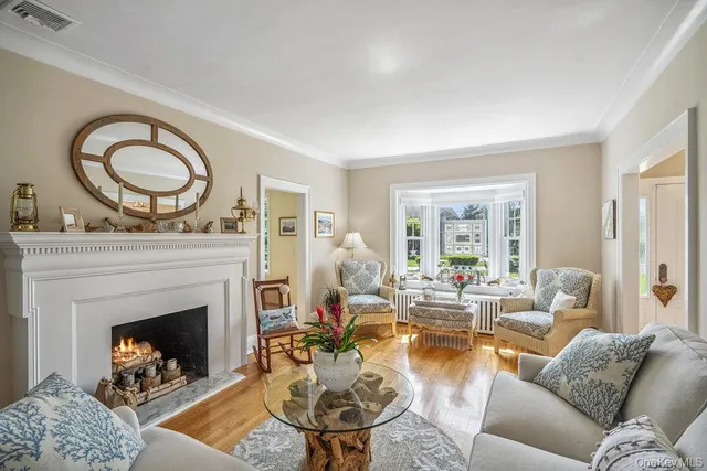 a living room with furniture a fireplace a window and a fireplace